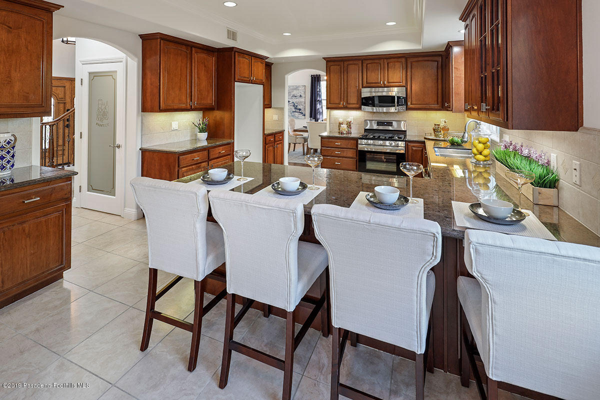 7215 Summitrose Street Tujunga, CA 91042 - Photo 17 of 47 a view of a dining room with furniture a kitchen and chandelier