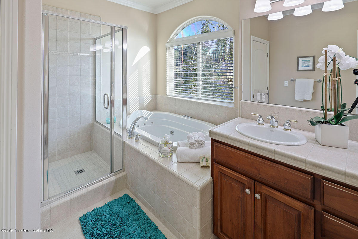 7215 Summitrose Street Tujunga, CA 91042 - Photo 37 of 47 a bathroom with a granite countertop sink a mirror a bathtub and shower