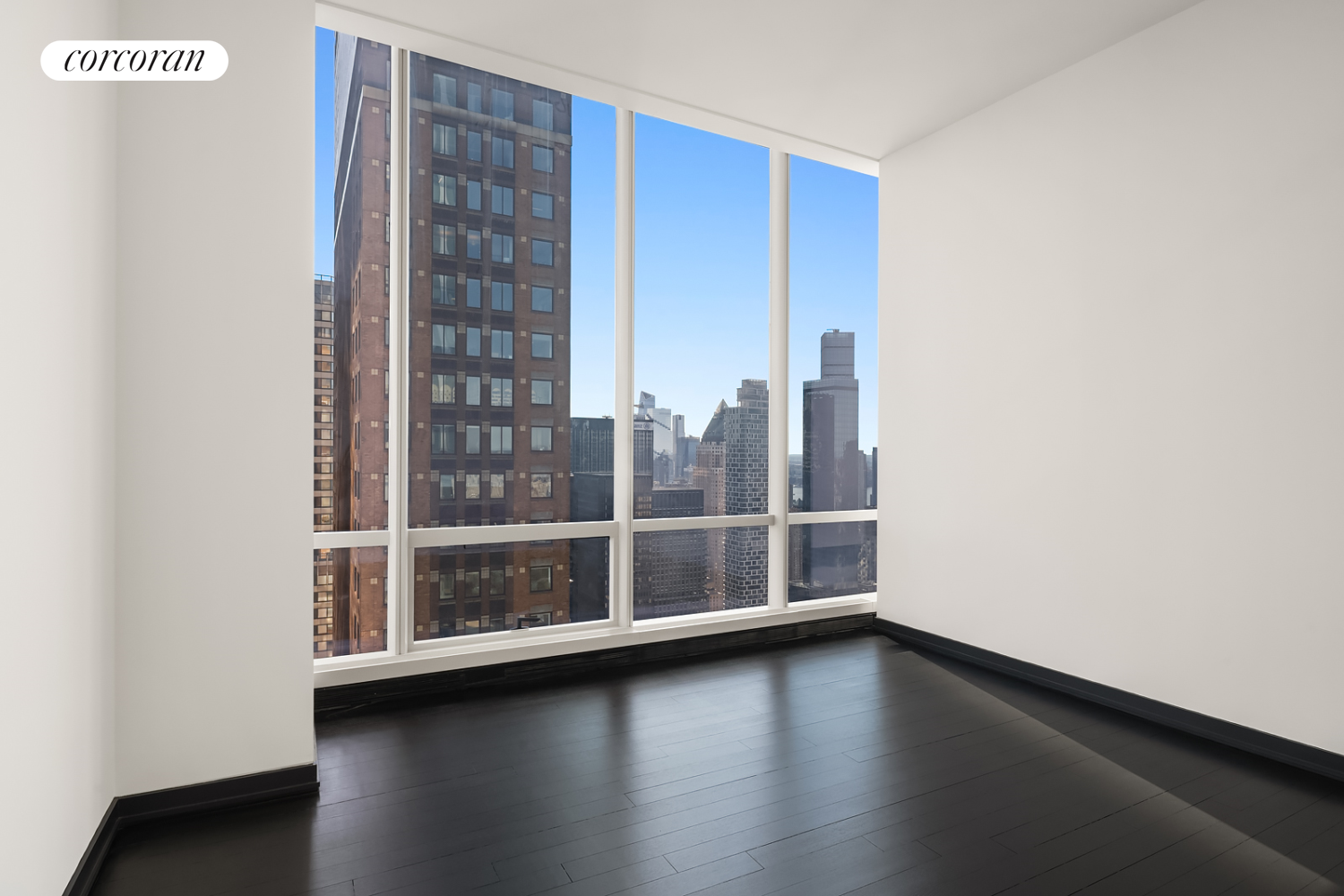 157 West 57th Street, Unit 56C Manhattan, NY 10019 - Photo 14 of 29 a view of an empty room with wooden floor and a window