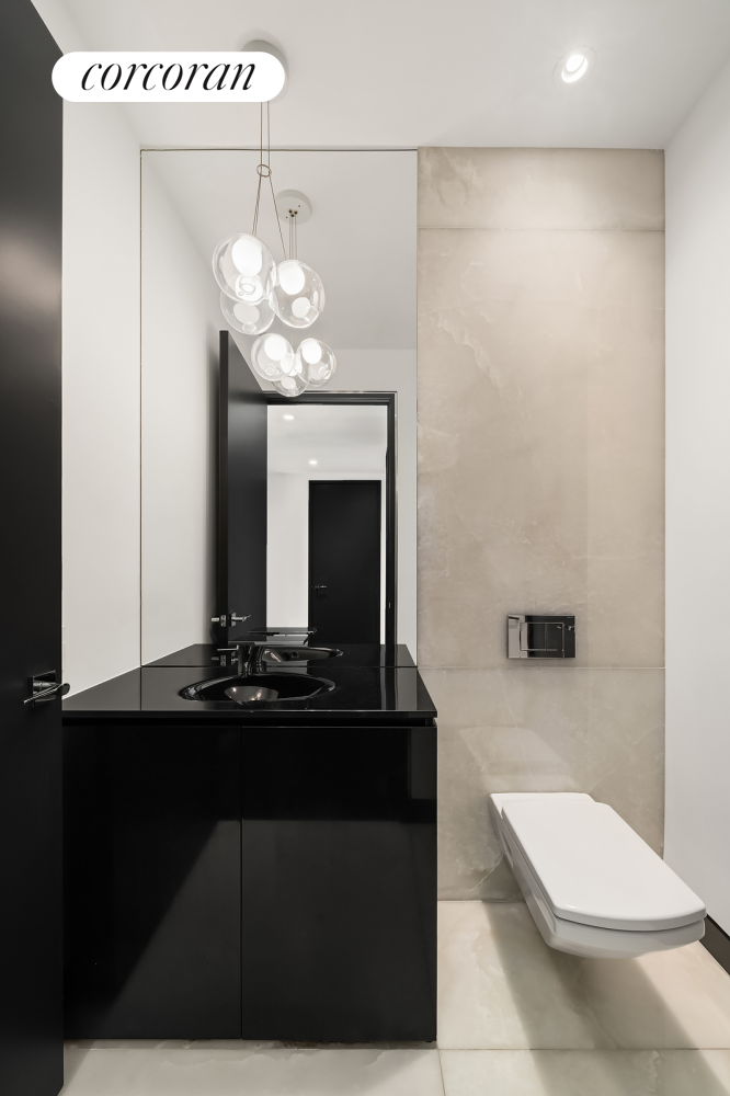 157 West 57th Street, Unit 56C Manhattan, NY 10019 - Photo 16 of 29 a bathroom with a sink a toilet and mirror