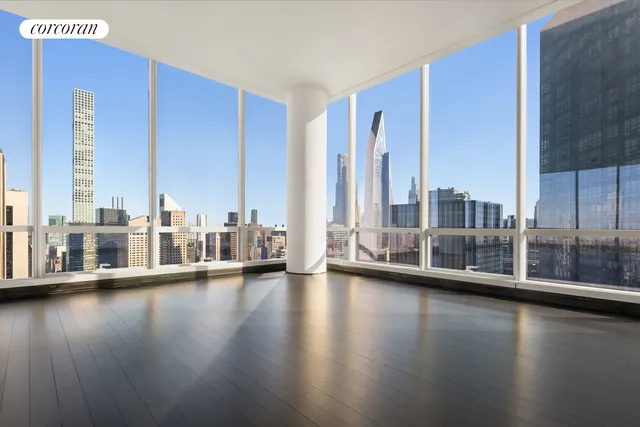 a view of a living room with floor to ceiling window and wooden floor