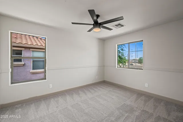 a view of empty room with window and ceiling fan