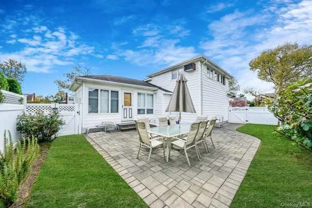 a backyard of a house with table and chairs