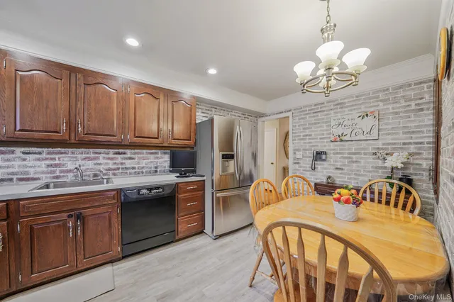 a kitchen with stainless steel appliances granite countertop a stove a sink dishwasher and a refrigerator with wooden cabinets