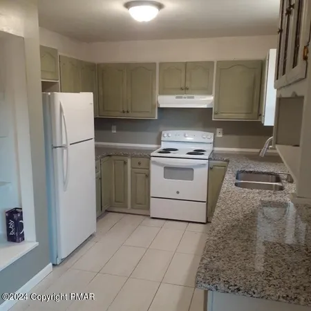 a kitchen with a stove a refrigerator and a sink