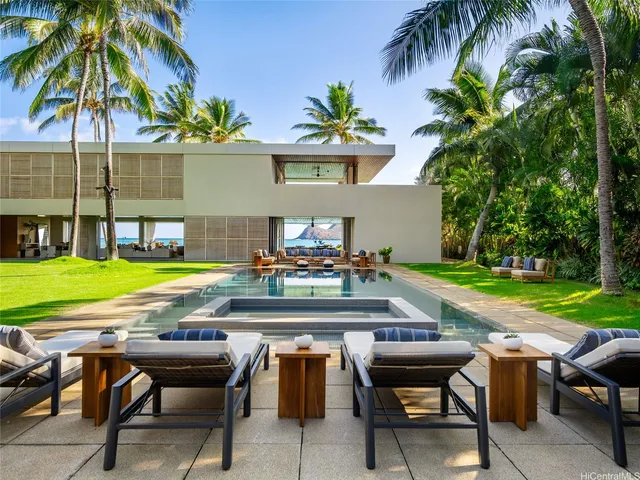 a view of a swimming pool with a table and chairs under an umbrella