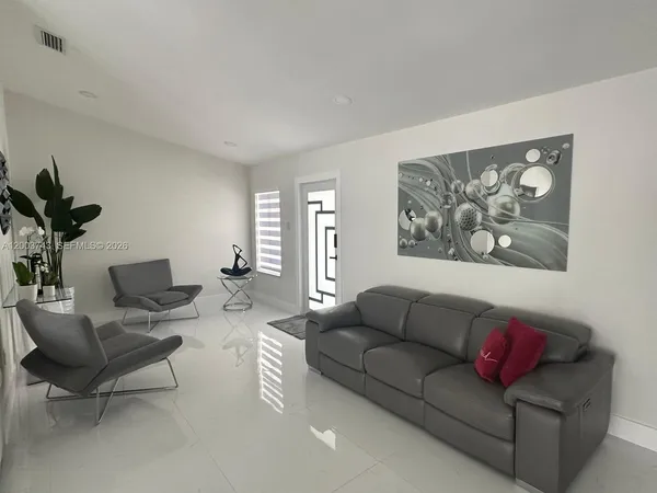 a living room with furniture and a potted plant
