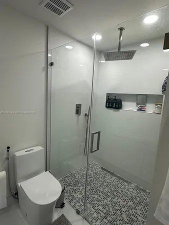 a bathroom with a toilet and a shower