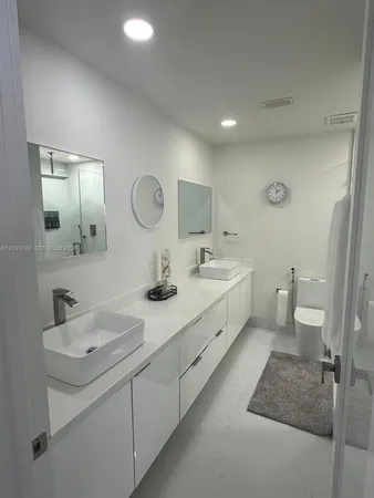 a spacious bathroom with a double vanity sink mirror and toilet
