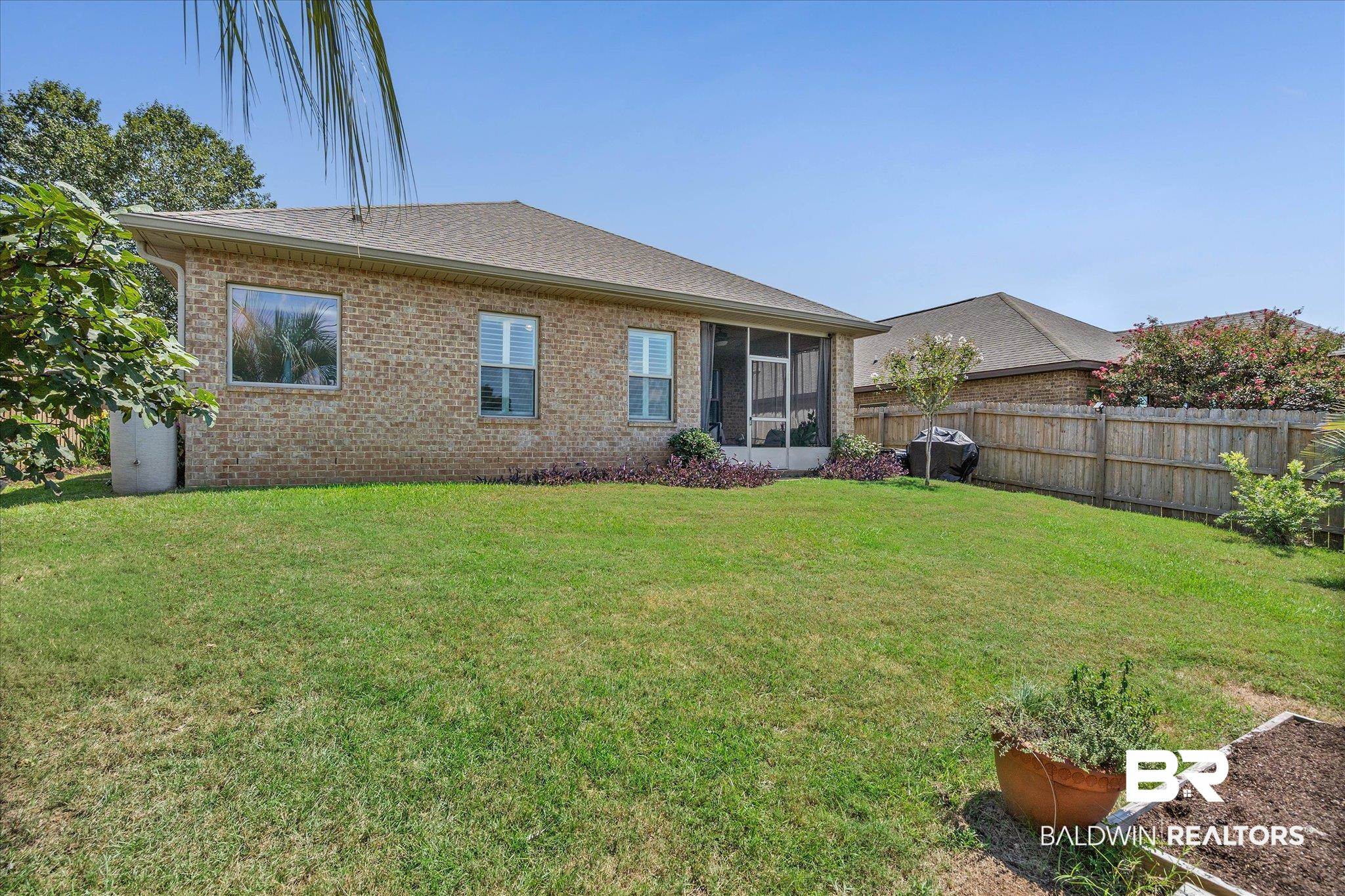 10677 Orkney Way Spanish Fort, AL 36527 - Photo 18 of 22 Rear view of house featuring a sunroom, brick siding, and a shingled roof
