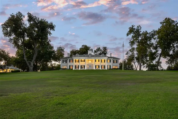 a sign board with grassy field in back