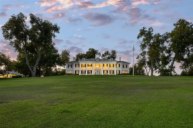 a sign board with grassy field in back