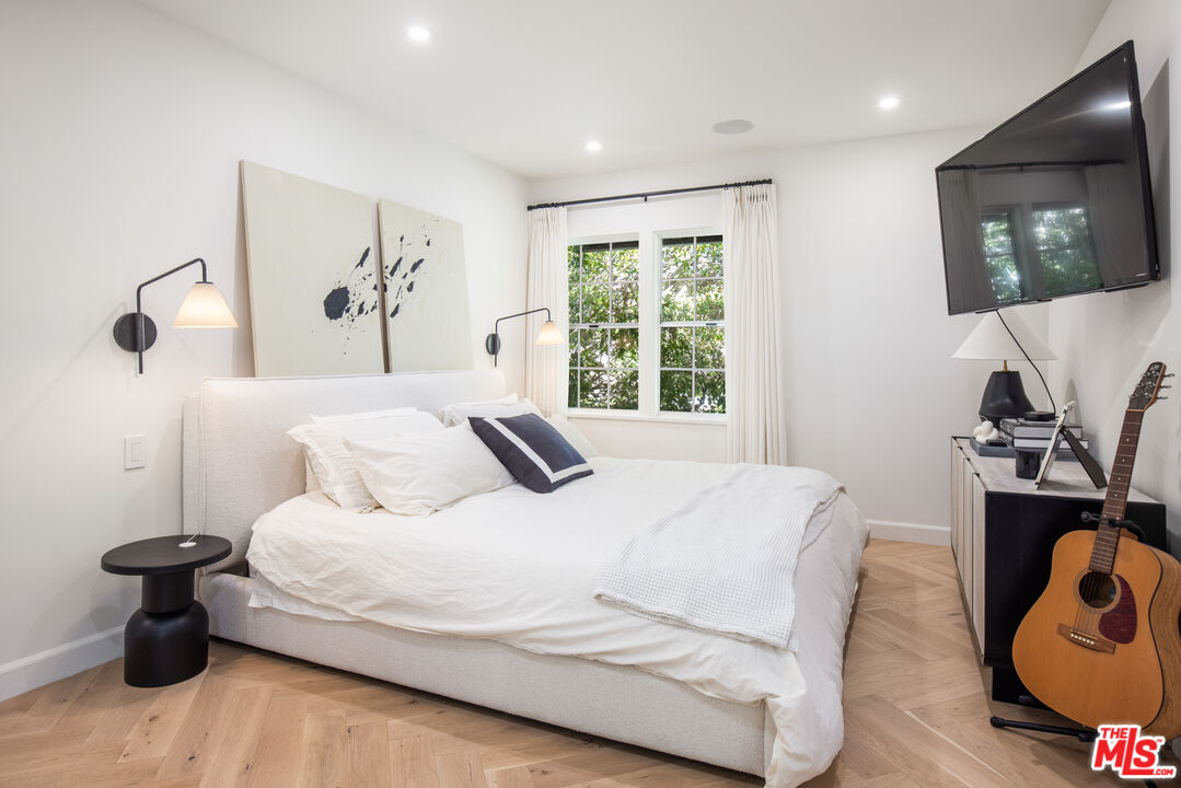 1570 Queens Road Los Angeles, CA 90069 - Photo 18 of 41 a bedroom with a bed and wooden floor