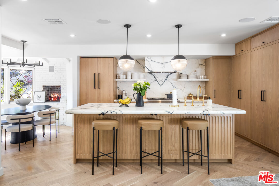 1570 Queens Road Los Angeles, CA 90069 - Photo 7 of 41 a kitchen with kitchen island granite countertop a table chairs sink and cabinets