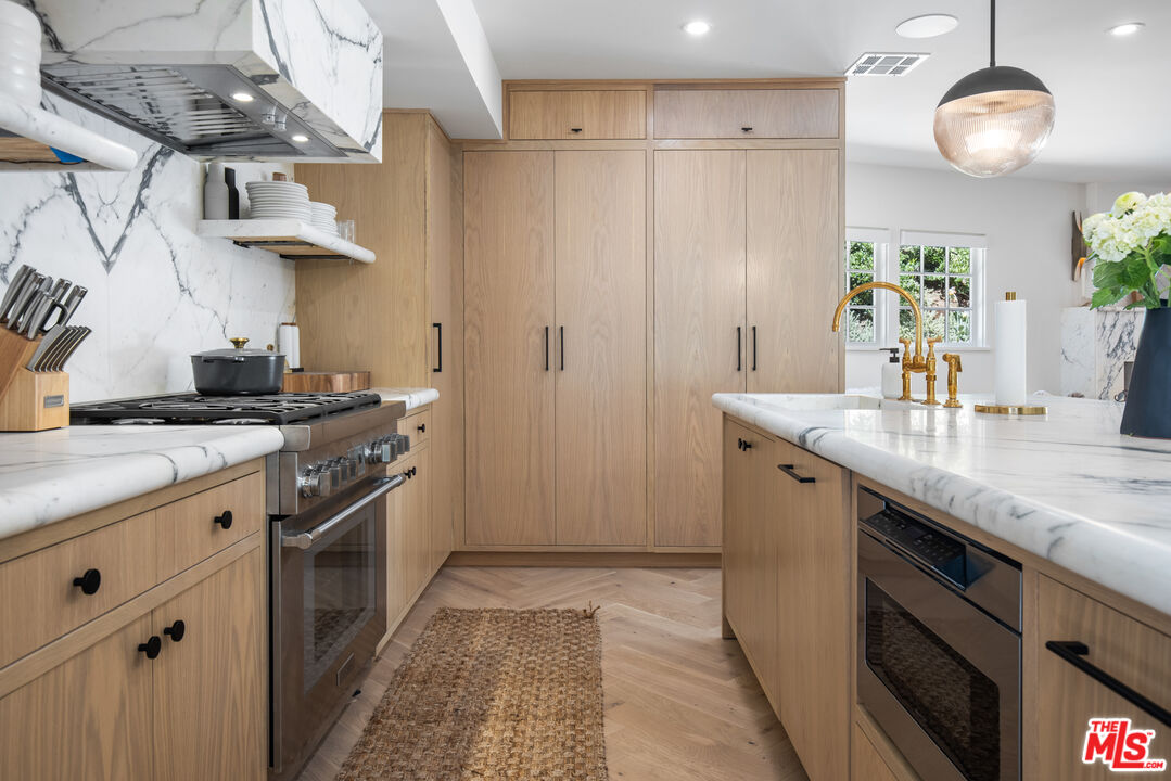 1570 Queens Road Los Angeles, CA 90069 - Photo 9 of 41 a kitchen with stainless steel appliances granite countertop a sink a stove and a refrigerator