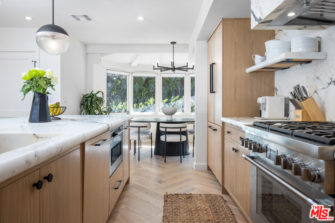 1570 Queens Road Los Angeles, CA 90069 - Photo 10 of 41 a kitchen with stainless steel appliances granite countertop a stove and a sink