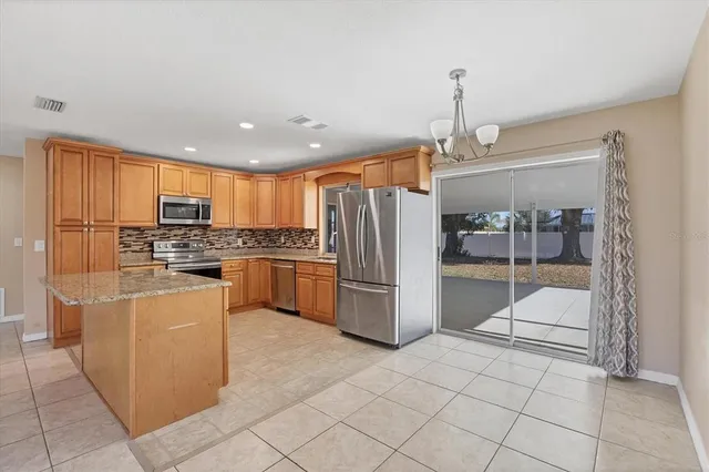 a kitchen with stainless steel appliances granite countertop a refrigerator and a stove top oven