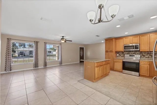 a kitchen with granite countertop a stove top oven a sink a counter space and cabinets