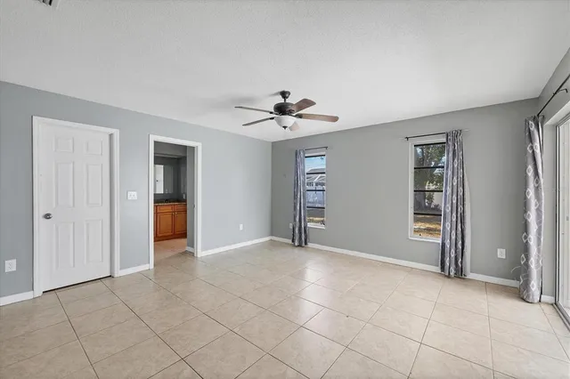 an empty room with closet and a ceiling fan