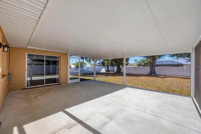 a view of an empty room with a fireplace and window