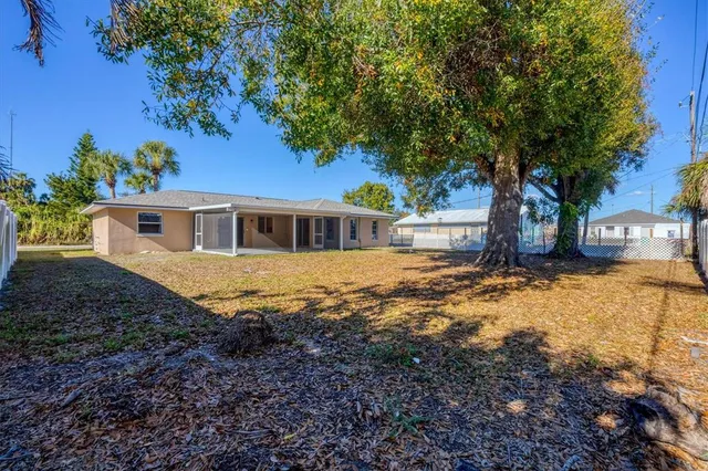 a view of a backyard with large trees and a barn