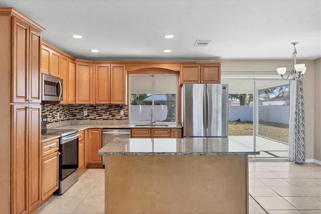 a kitchen with stainless steel appliances granite countertop a refrigerator and a stove top oven
