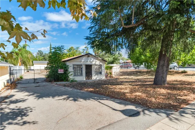 a front view of a house with a yard and trees
