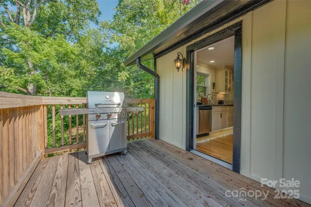 a view of a house with a yard plants and large tree