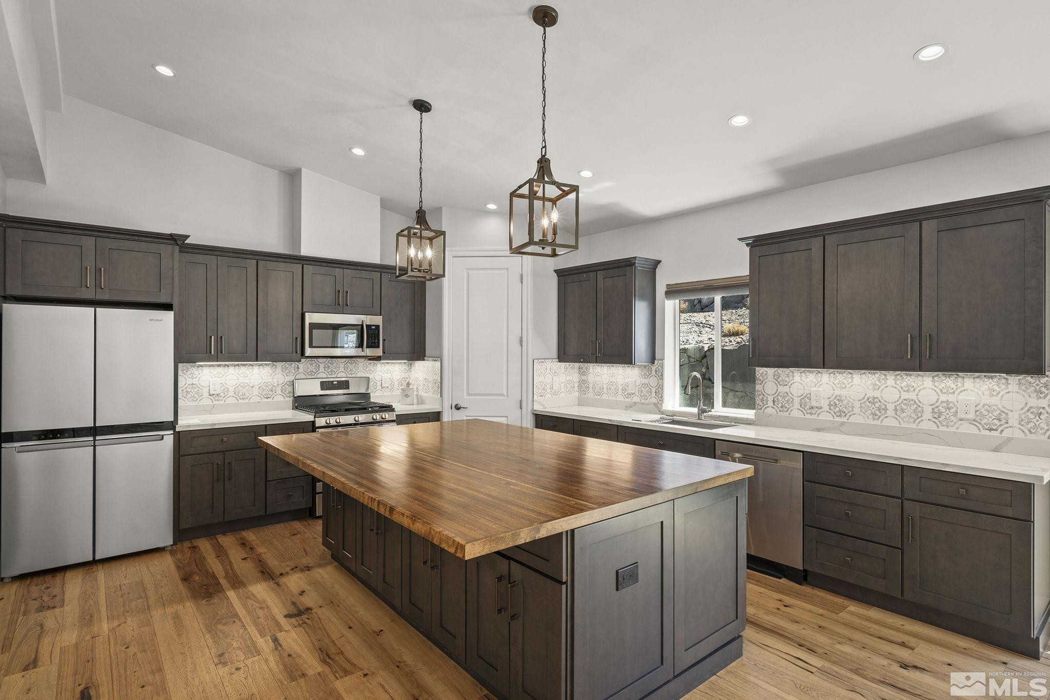 3880 Royer Court Reno, NV 89509 - Photo 11 of 29 a kitchen with stainless steel appliances granite countertop a sink a stove and a refrigerator