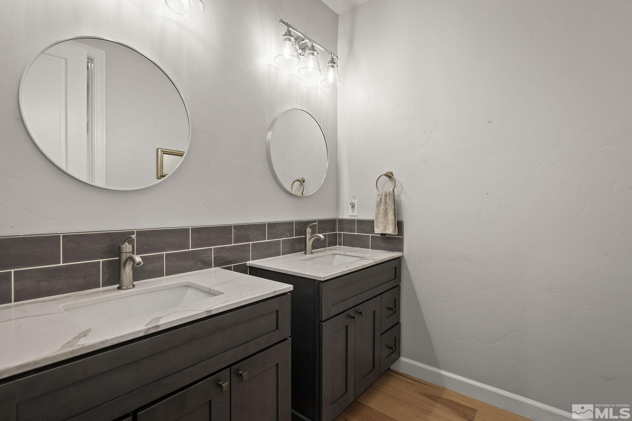 3880 Royer Court Reno, NV 89509 - Photo 18 of 29 a bathroom with a granite countertop sink a mirror and vanity