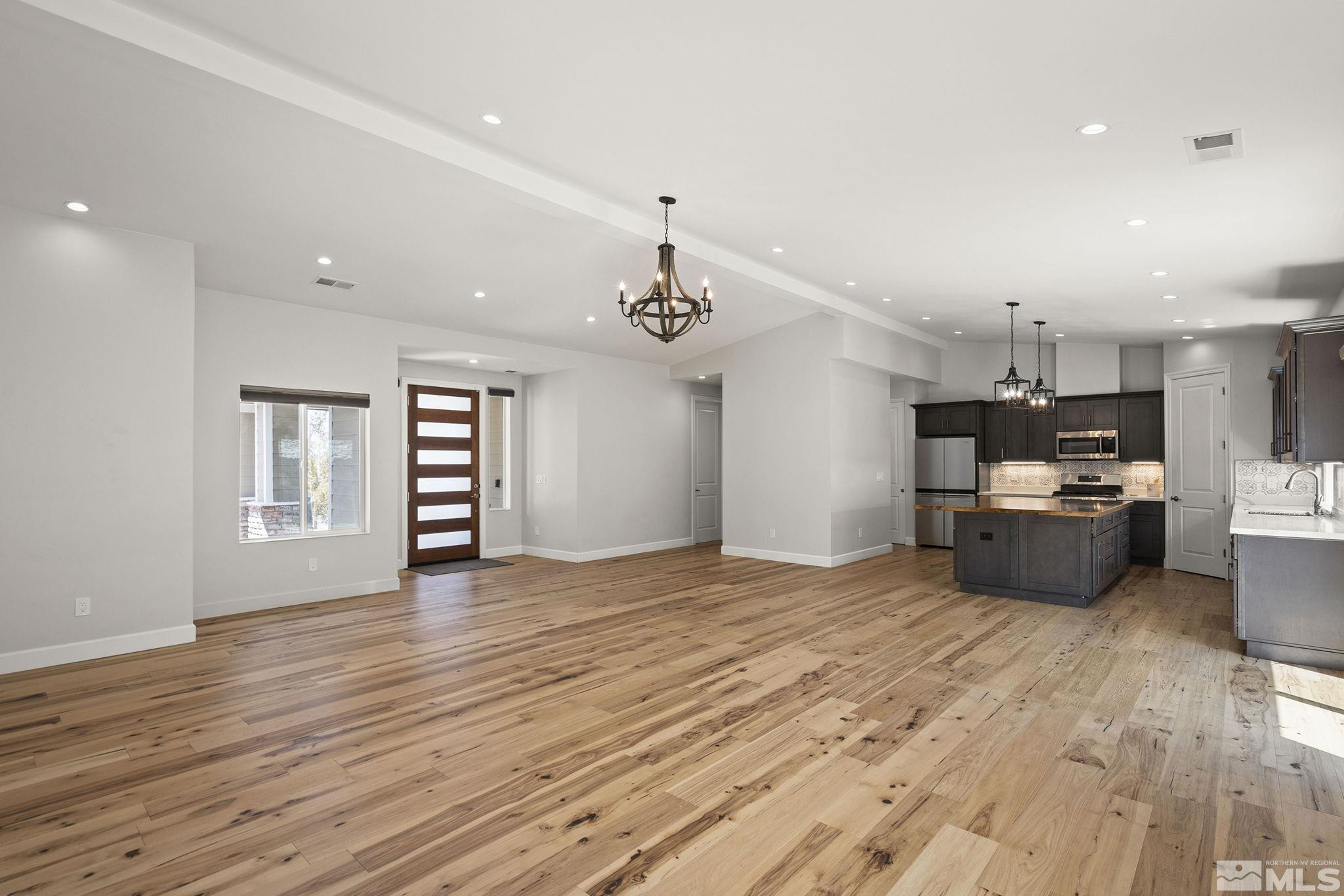 3880 Royer Court Reno, NV 89509 - Photo 10 of 29 a kitchen with stainless steel appliances a refrigerator a sink dishwasher a stove and a window with wooden floor
