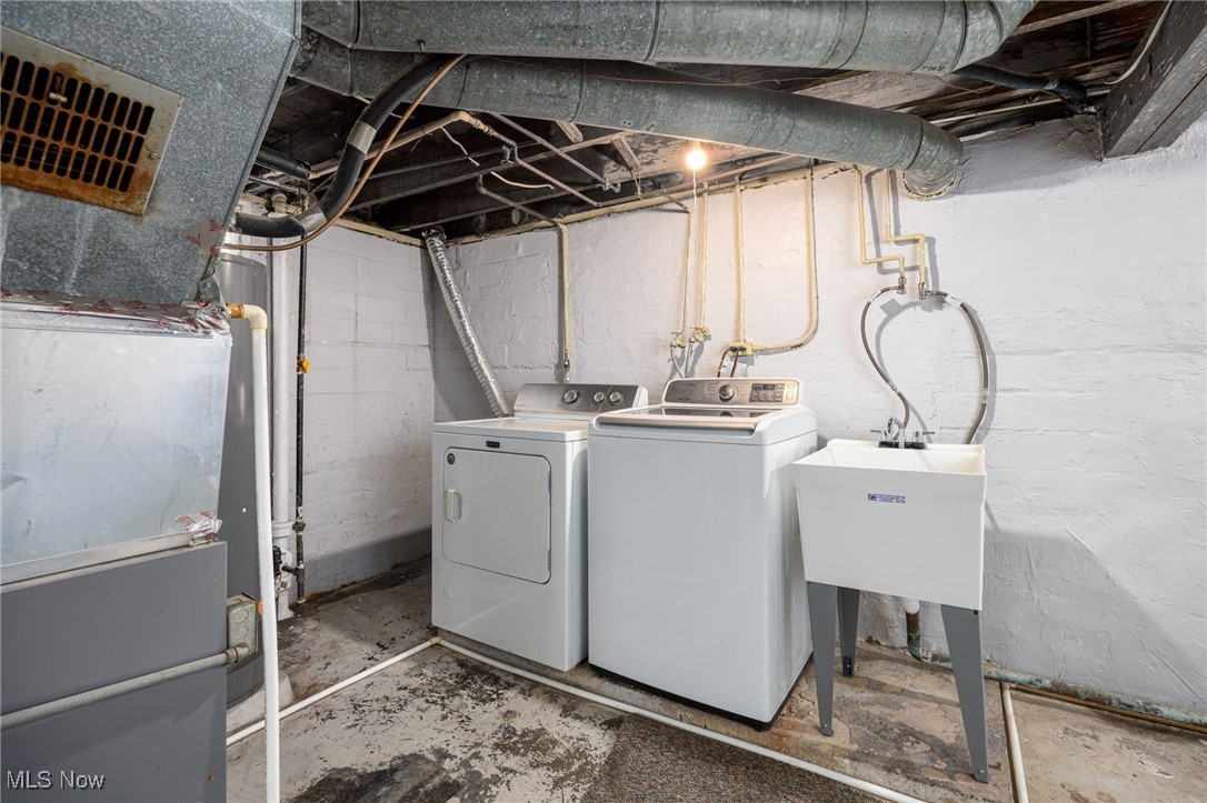 3368 Berea Road Cleveland, OH 44111 - Photo 23 of 26 Laundry area featuring washer and dryer, concrete flooring, and heating unit