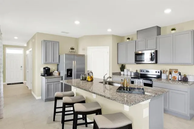 a kitchen with stainless steel appliances granite countertop sink microwave and cabinets