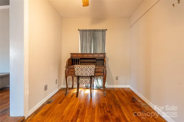 a view of a room with wooden floor and bench