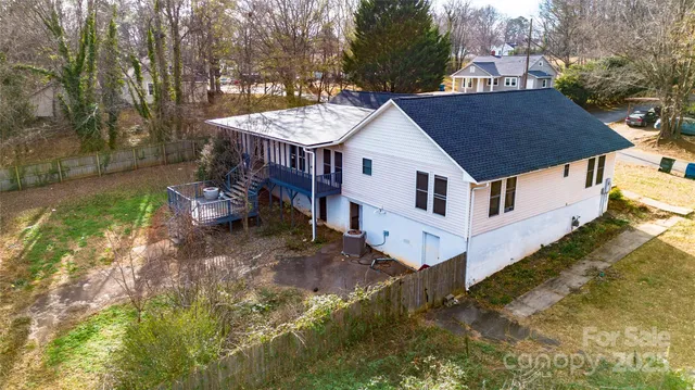 a view of a house with a yard balcony and wooden fence