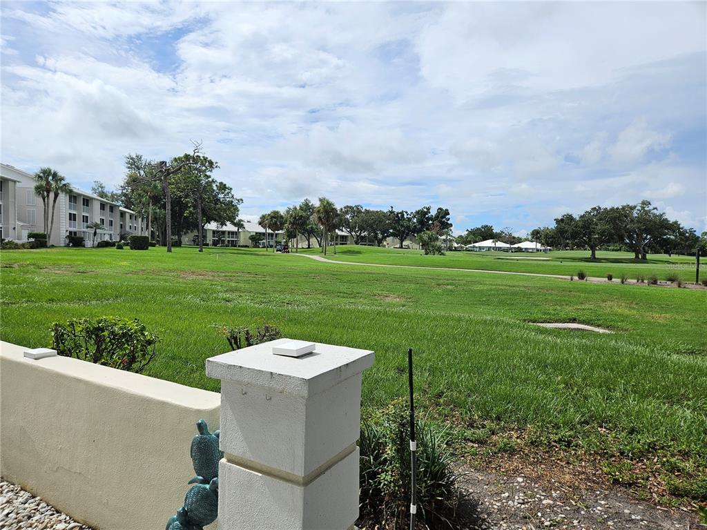 435 Cerromar Lane, Unit 329 Venice, FL 34293 - Photo 14 of 57 a view of a white house with a big yard and a fountain