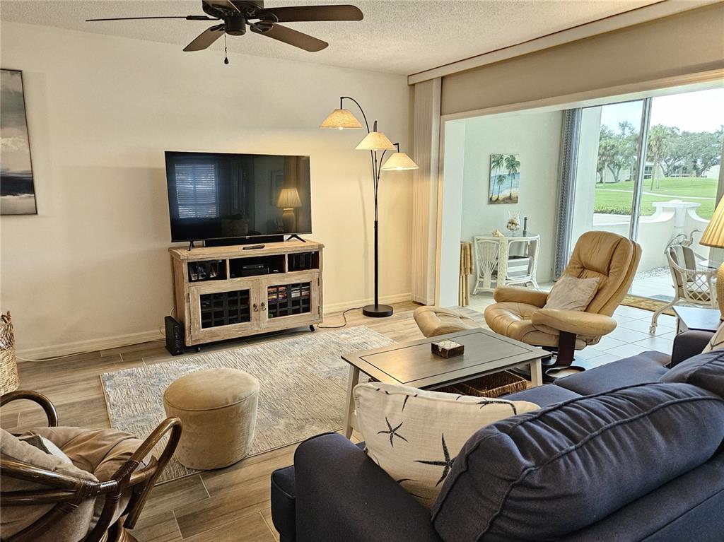 435 Cerromar Lane, Unit 329 Venice, FL 34293 - Photo 15 of 57 a living room with furniture and a flat screen tv