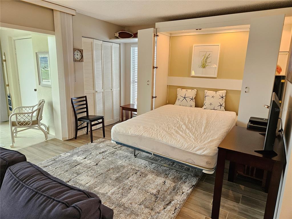 435 Cerromar Lane, Unit 329 Venice, FL 34293 - Photo 19 of 57 a bedroom with a bed a table and chair