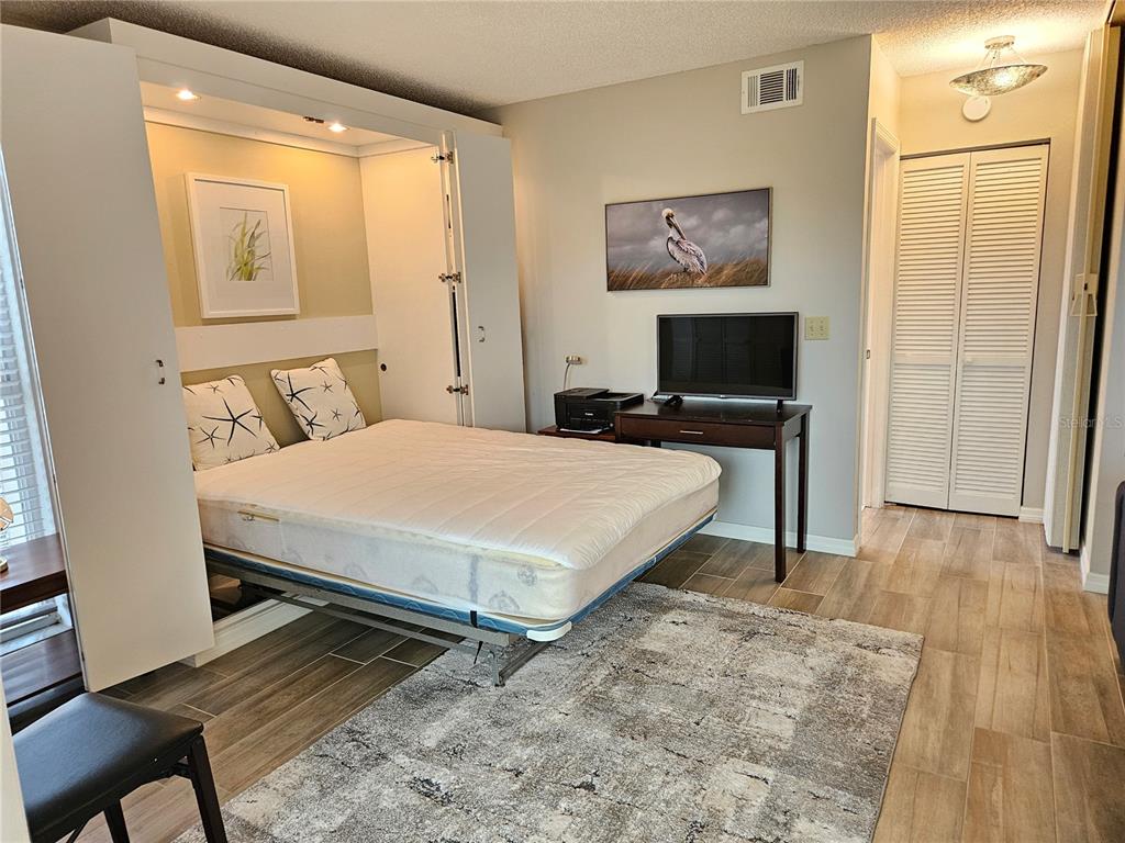 435 Cerromar Lane, Unit 329 Venice, FL 34293 - Photo 20 of 57 a bedroom with a bed and wooden floor