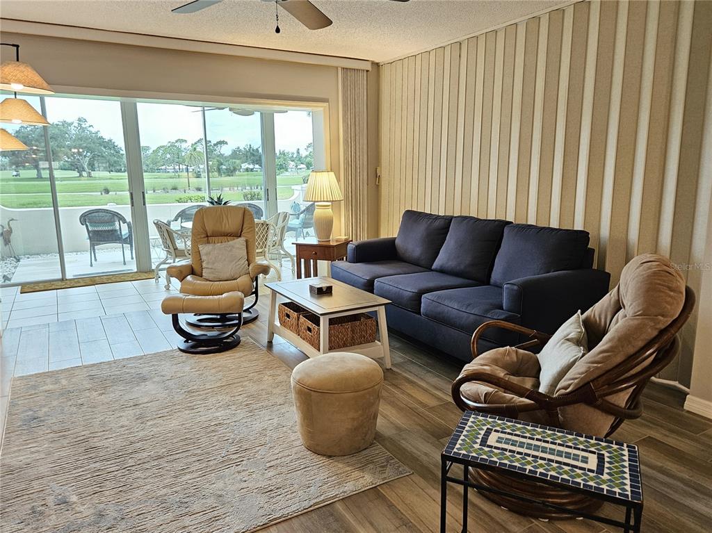 435 Cerromar Lane, Unit 329 Venice, FL 34293 - Photo 26 of 57 a living room with furniture and a floor to ceiling window