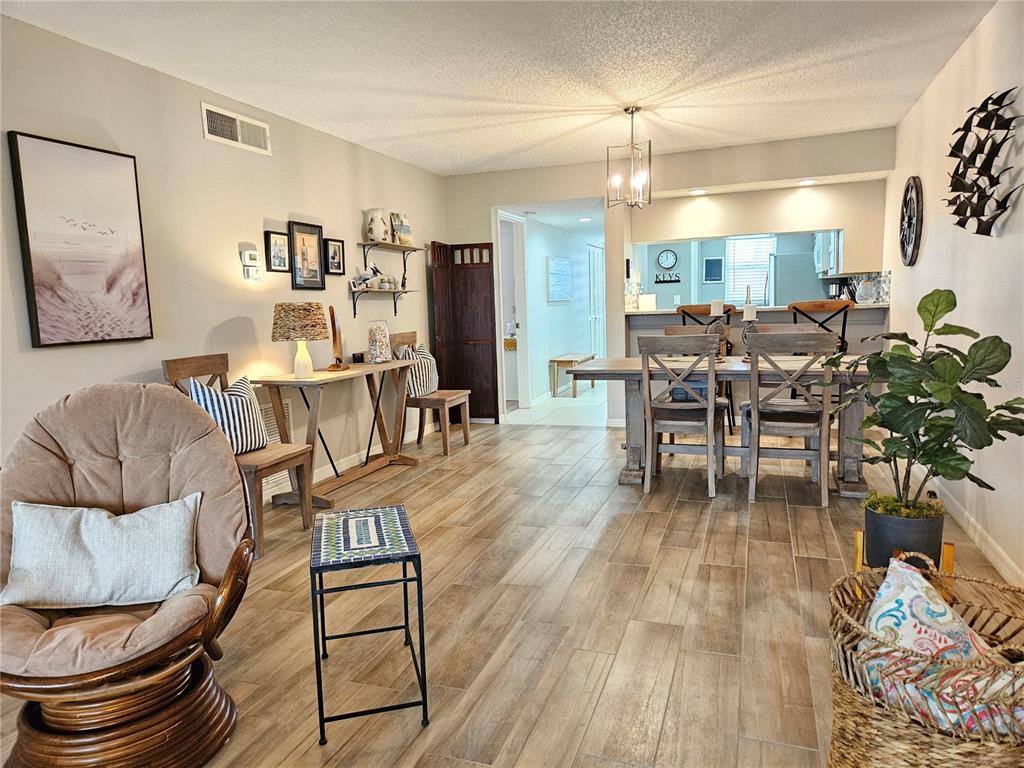 435 Cerromar Lane, Unit 329 Venice, FL 34293 - Photo 33 of 57 a living room with furniture and a dining table with wooden floor
