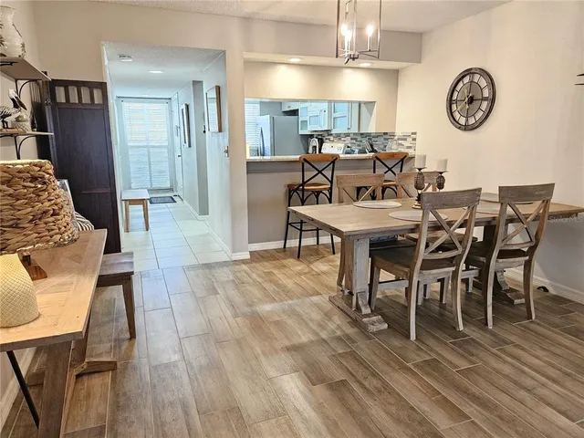 a kitchen with granite countertop a sink chairs and refrigerator