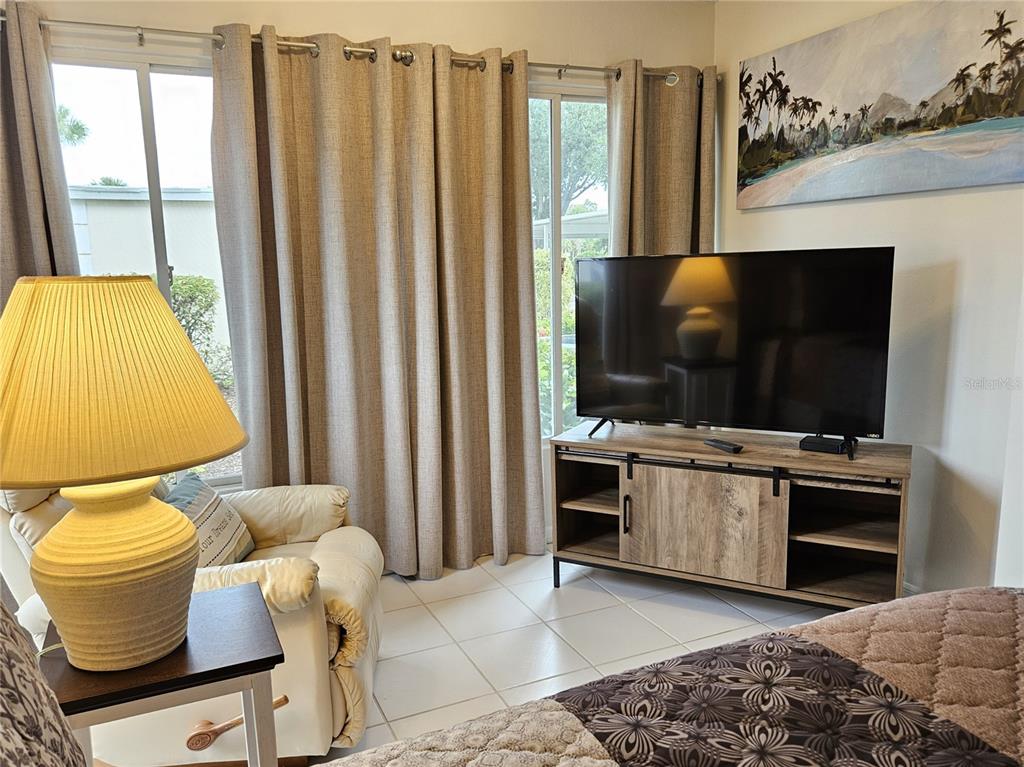 435 Cerromar Lane, Unit 329 Venice, FL 34293 - Photo 43 of 57 a living room with furniture and a flat screen tv