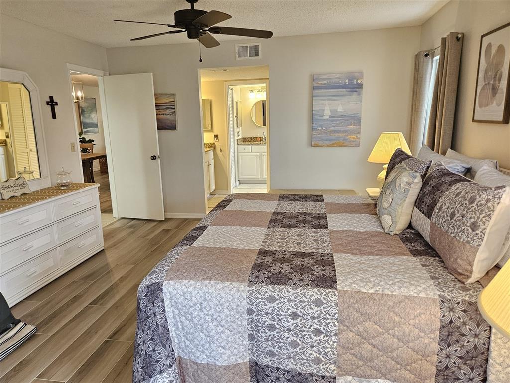 435 Cerromar Lane, Unit 329 Venice, FL 34293 - Photo 45 of 57 a bedroom with a bed and a chandelier