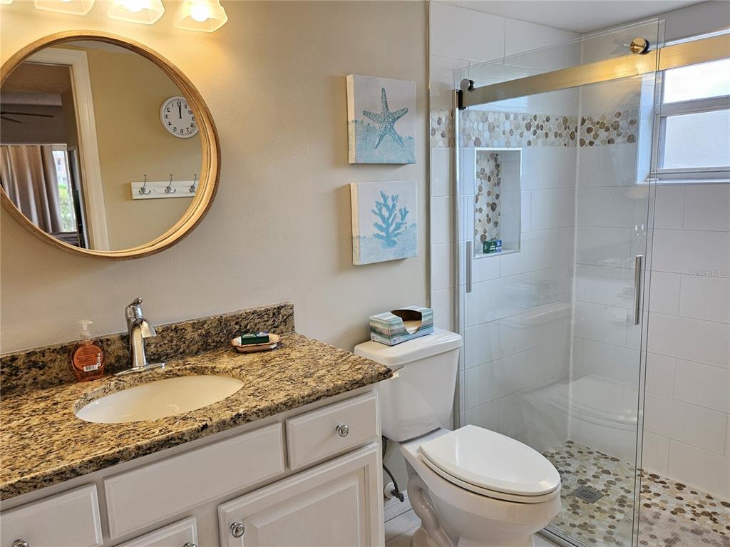 435 Cerromar Lane, Unit 329 Venice, FL 34293 - Photo 47 of 57 a bathroom with a granite countertop sink mirror vanity and toilet