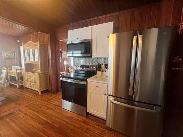 a kitchen with granite countertop white cabinets and white appliances