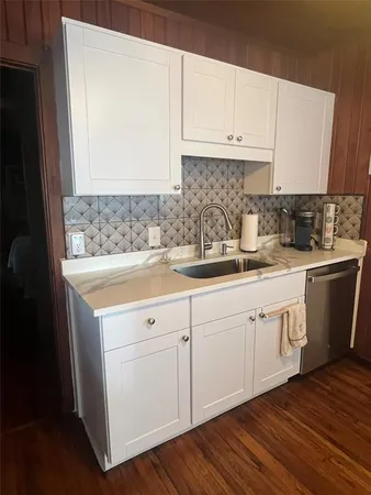 a kitchen with granite countertop a sink cabinets and stainless steel appliances