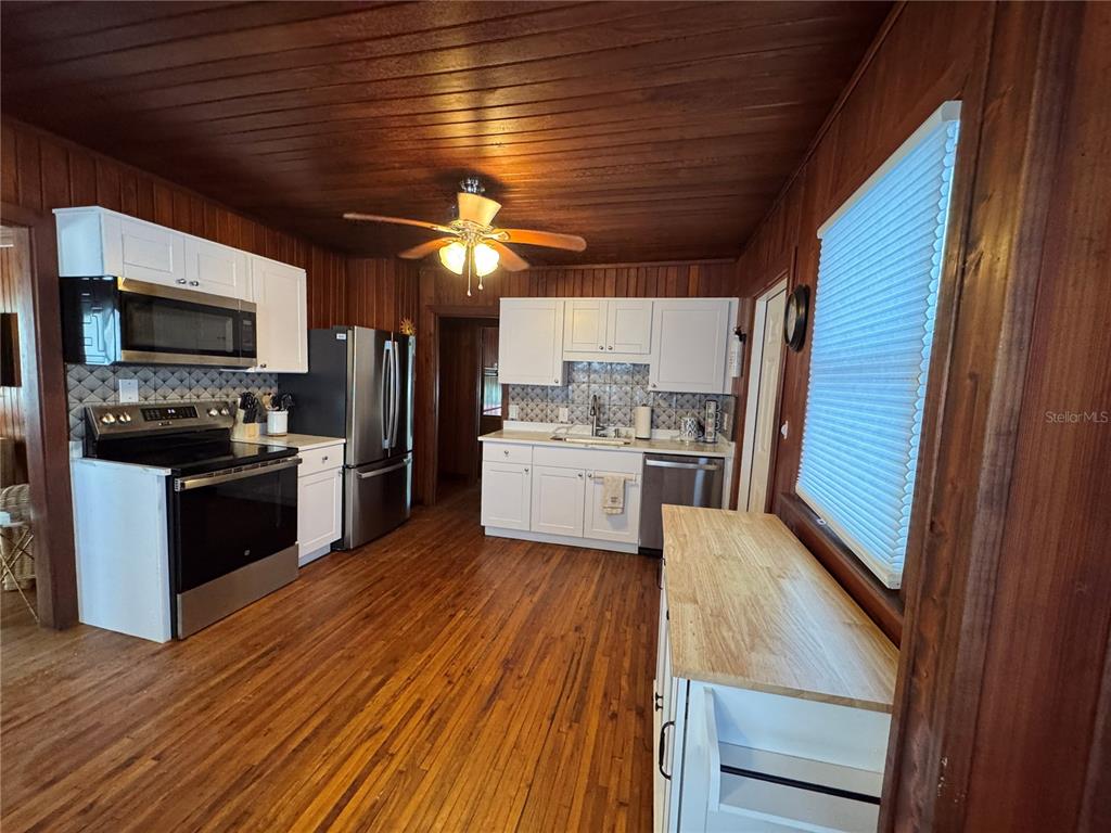 5 82nd Avenue Treasure Island, FL 33706 - Photo 20 of 35 a kitchen with a refrigerator wooden floor and a sink
