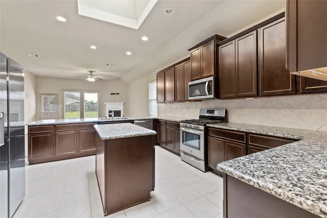a kitchen with stainless steel appliances granite countertop a stove sink and cabinets