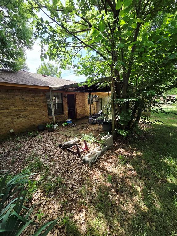 722 South Church Street Pilot Point, TX 76258 - Photo 20 of 37 a view of a backyard with table and chairs under an umbrella